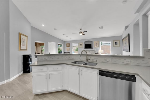 kitchen featuring a sink, stainless steel dishwasher, backsplash, and visible vents