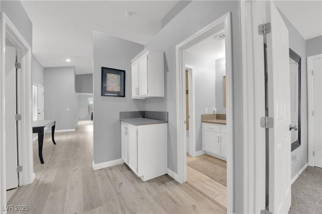 hallway featuring baseboards, recessed lighting, light wood finished floors, and visible vents