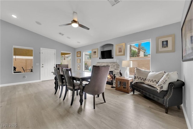 dining space featuring a ceiling fan, visible vents, lofted ceiling, and light wood-type flooring