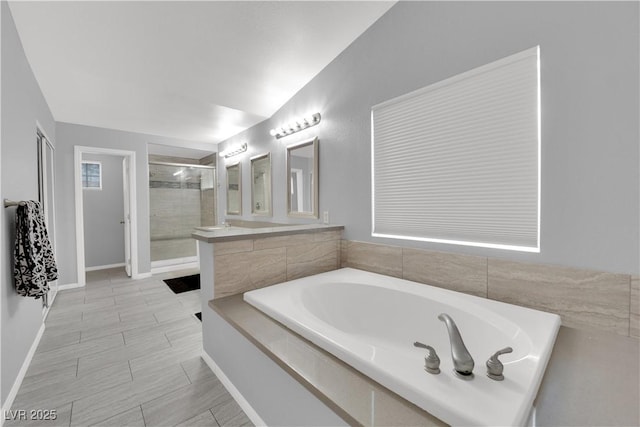 full bath with vanity, a shower stall, and a garden tub