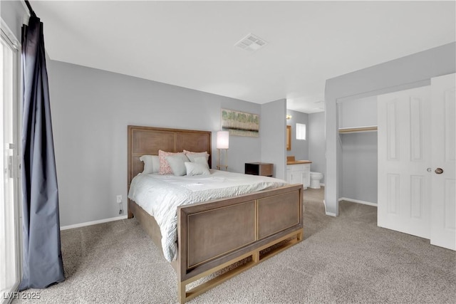 bedroom featuring visible vents, carpet floors, baseboards, a closet, and ensuite bath