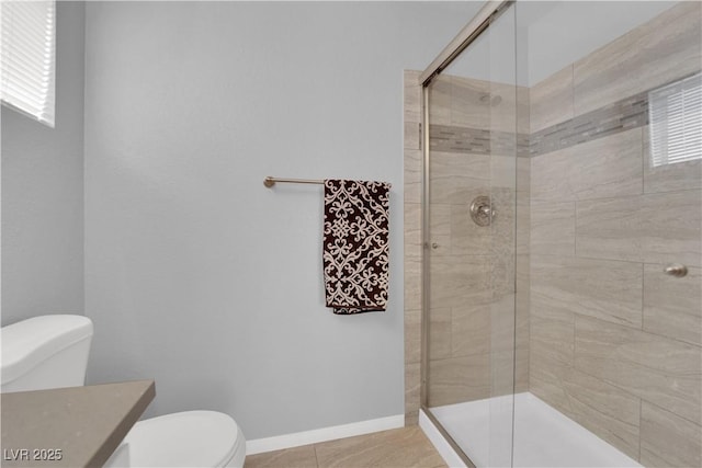 bathroom featuring tile patterned floors, a stall shower, and toilet