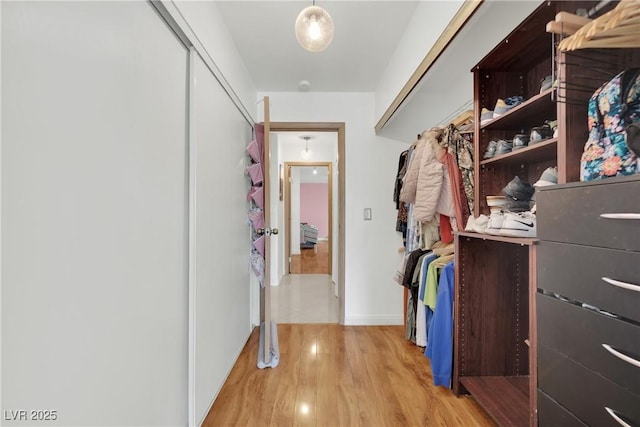 walk in closet with wood finished floors