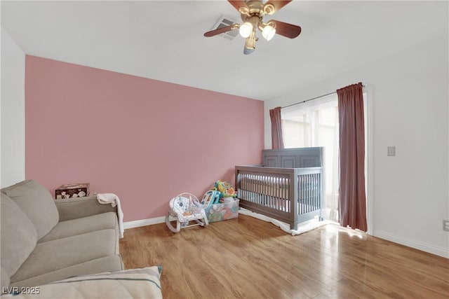 bedroom featuring baseboards, a ceiling fan, and wood finished floors