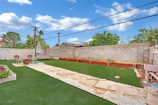 view of yard featuring a fenced backyard and an outdoor fire pit