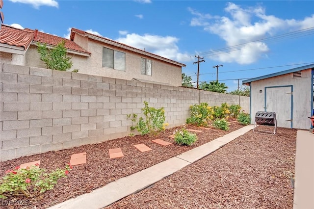view of yard featuring a fenced backyard and an outbuilding