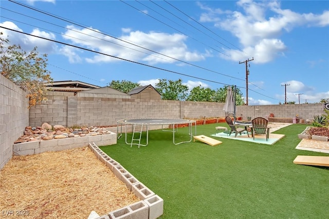 view of yard featuring a fenced backyard, a trampoline, and a patio