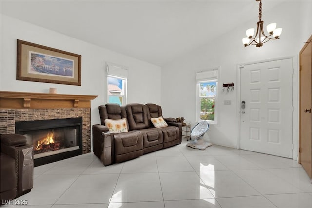 living area with an inviting chandelier, a tiled fireplace, a wealth of natural light, and lofted ceiling