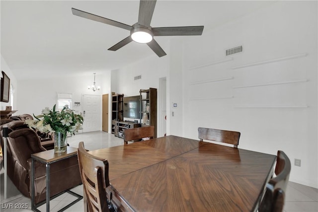 dining space with vaulted ceiling, visible vents, light tile patterned floors, and ceiling fan with notable chandelier