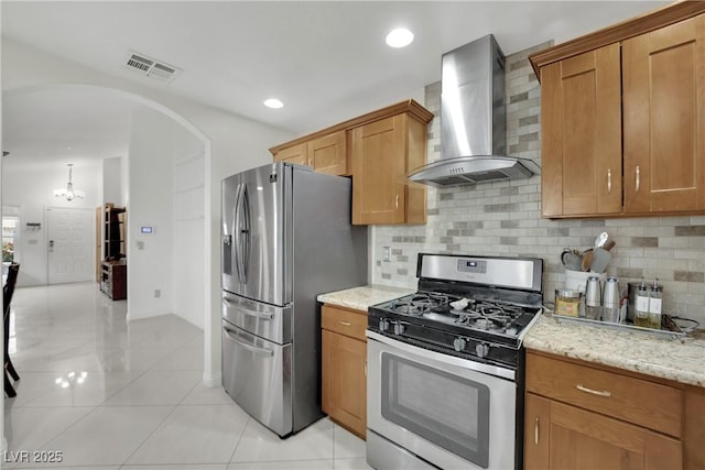 kitchen featuring visible vents, appliances with stainless steel finishes, tasteful backsplash, wall chimney exhaust hood, and light tile patterned flooring