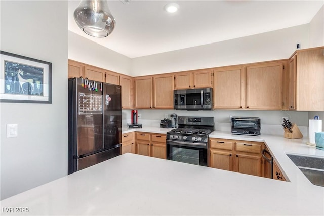 kitchen featuring light countertops, a toaster, a sink, stainless steel appliances, and recessed lighting