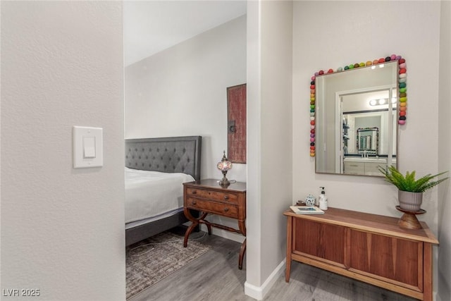 bedroom featuring baseboards and wood finished floors