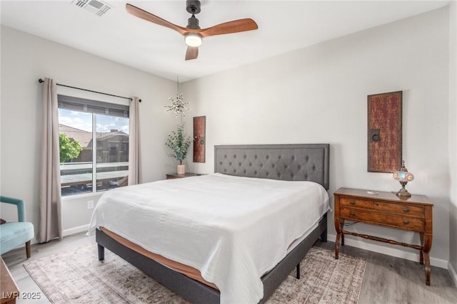 bedroom with visible vents, baseboards, ceiling fan, and wood finished floors