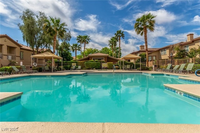 community pool featuring fence and a residential view