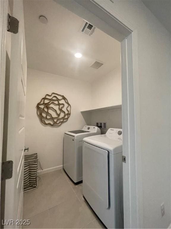 laundry area featuring laundry area, visible vents, light tile patterned floors, baseboards, and washer and dryer