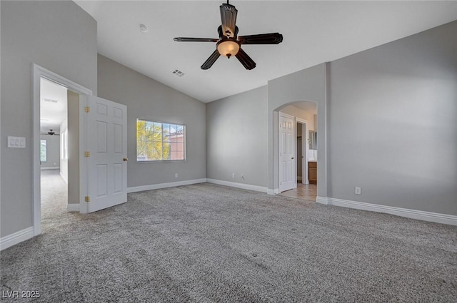 interior space with arched walkways, ceiling fan, and light colored carpet