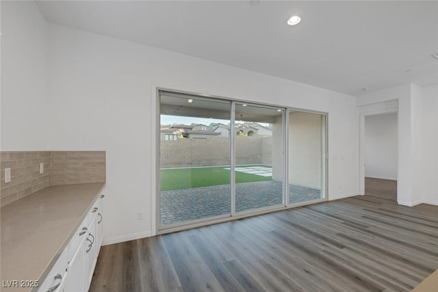 unfurnished dining area with recessed lighting, baseboards, and dark wood-style floors