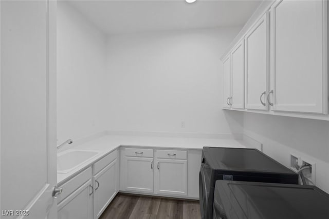 laundry area with cabinet space, a sink, dark wood finished floors, recessed lighting, and washer / dryer