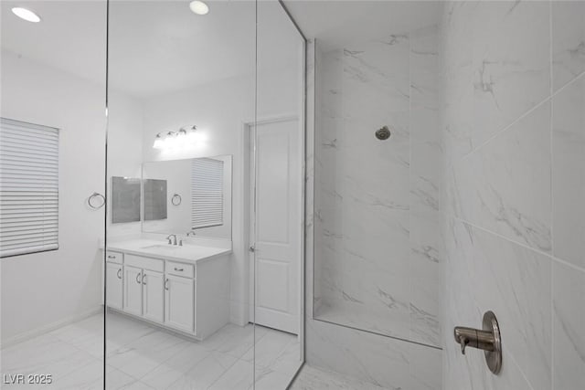 full bath with vanity, marble finish floor, baseboards, and a marble finish shower
