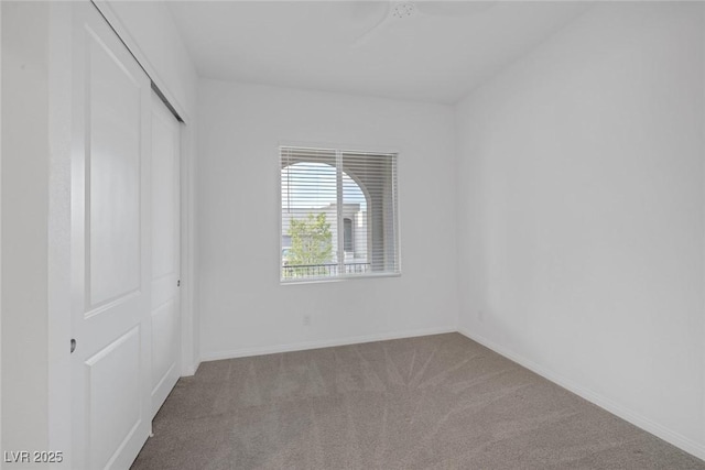 unfurnished bedroom with carpet floors, baseboards, and a closet