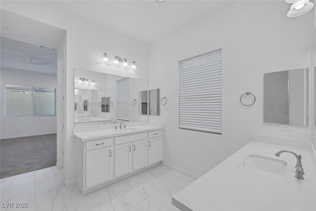 full bathroom with a sink, marble finish floor, a ceiling fan, baseboards, and two vanities