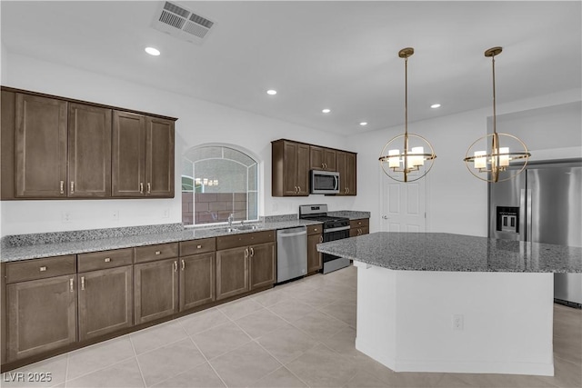6142 Kelson Creek Ct, Las Vegas, NV 89118 - kitchen with dark brown cabinetry, visible vents, a chandelier, stone counters, and stainless steel appliances