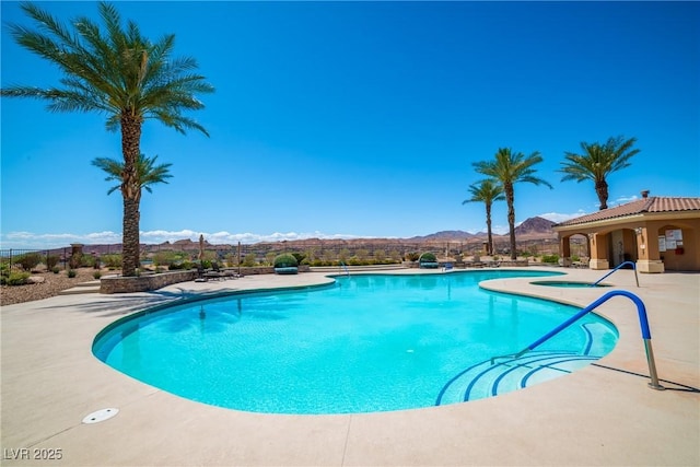 pool featuring a mountain view and a patio area