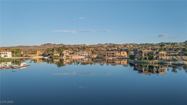 view of water feature featuring a residential view, a boat dock, and a mountain view