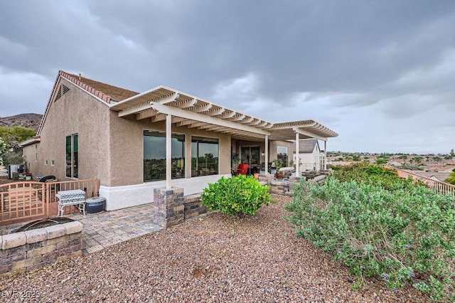 2110 King Mesa Dr, Henderson, NV 89012 - rear view of property featuring a pergola, a patio, stucco siding, and a fire pit