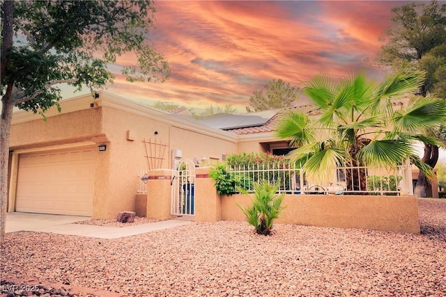 9000 Litchfield Ave, Las Vegas, NV 89134 - view of front of home featuring fence, stucco siding, roof mounted solar panels, an attached garage, and driveway