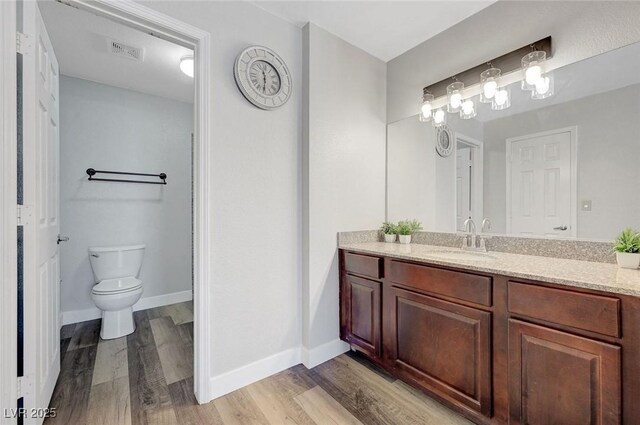 2451 N Rainbow Blvd Unit 2144, Las Vegas, NV 89108 - bathroom with vanity, wood finished floors, toilet, and baseboards