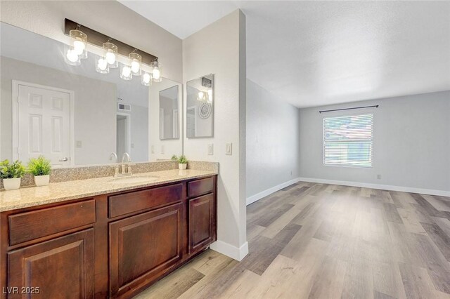 2451 N Rainbow Blvd Unit 2144, Las Vegas, NV 89108 - bathroom featuring wood finished floors, vanity, and baseboards