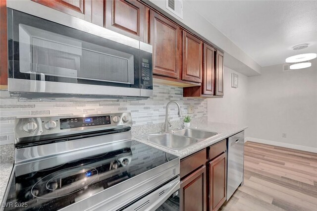 2451 N Rainbow Blvd Unit 2144, Las Vegas, NV 89108 - kitchen featuring stainless steel appliances, a sink, decorative backsplash, and baseboards