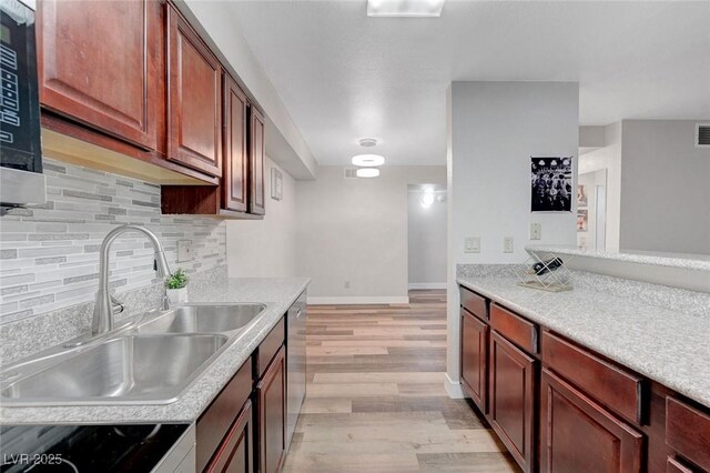 2451 N Rainbow Blvd Unit 2144, Las Vegas, NV 89108 - kitchen featuring a sink, light wood finished floors, decorative backsplash, range, and light countertops