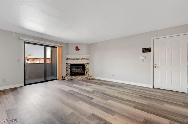 2451 N Rainbow Blvd Unit 2144, Las Vegas, NV 89108 - unfurnished living room with wood finished floors, baseboards, and a stone fireplace