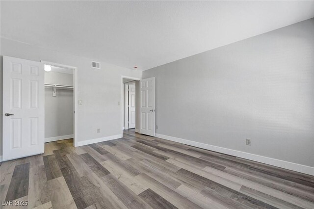 2451 N Rainbow Blvd Unit 2144, Las Vegas, NV 89108 - unfurnished bedroom with wood finished floors, baseboards, a closet, and a spacious closet