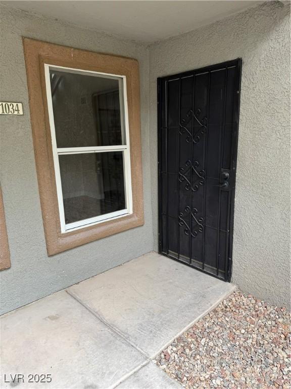 view of exterior entry featuring stucco siding