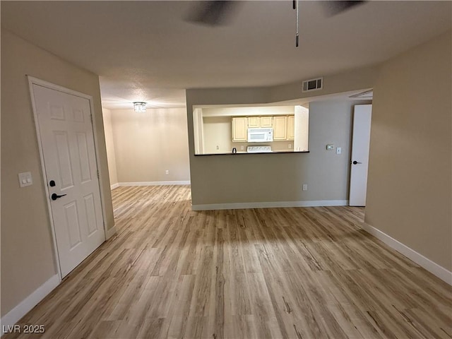 unfurnished living room featuring baseboards, light wood-style flooring, and visible vents