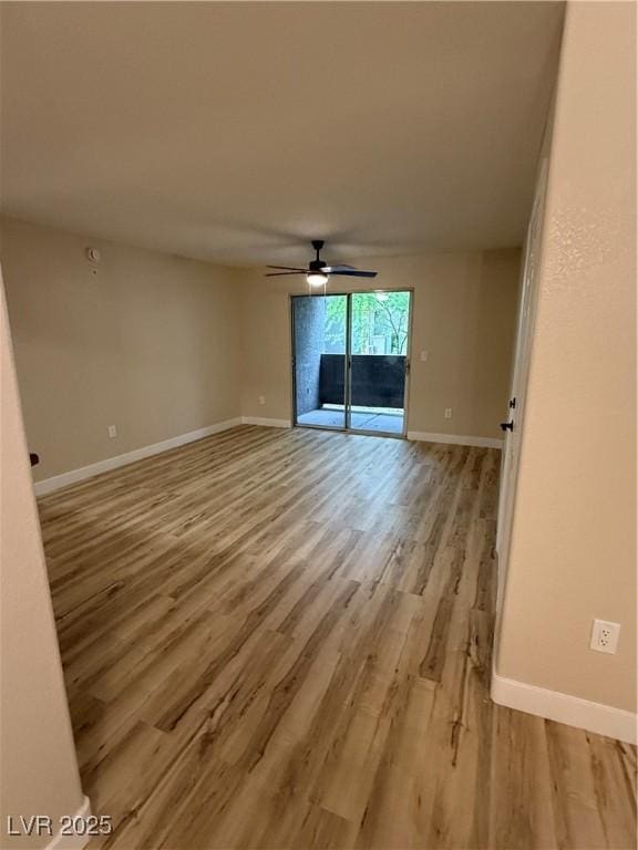 empty room with a ceiling fan, baseboards, and light wood-type flooring