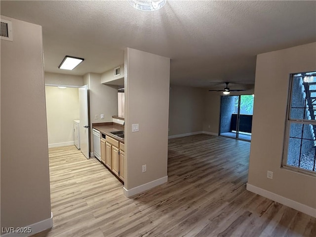 kitchen featuring baseboards, light wood-style flooring, and dishwasher
