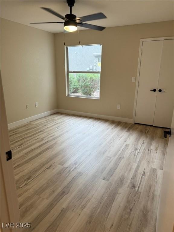 spare room with ceiling fan, baseboards, and wood finished floors