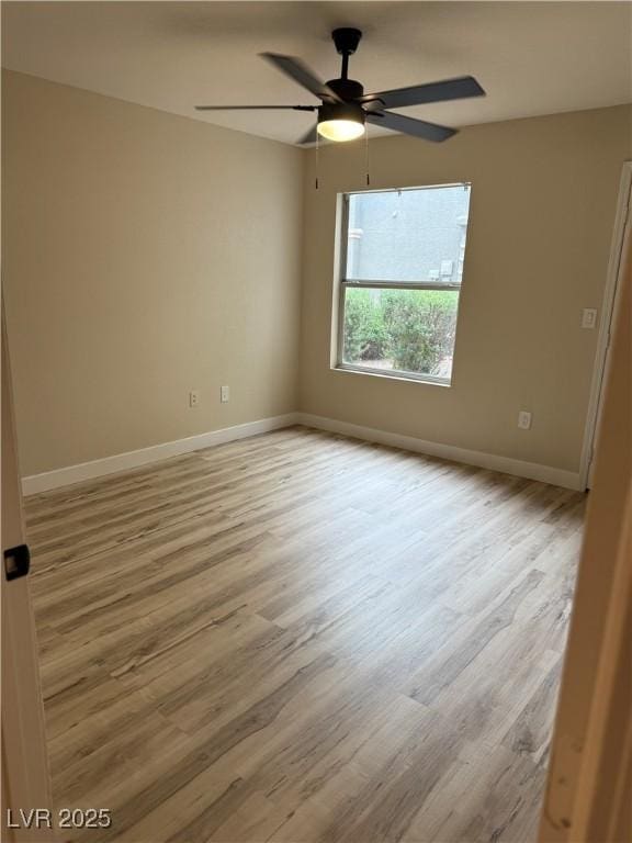 empty room featuring baseboards, ceiling fan, and wood finished floors