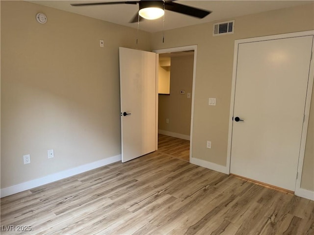 unfurnished bedroom with baseboards, a ceiling fan, light wood-style flooring, and visible vents