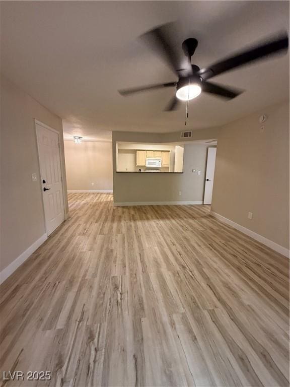 unfurnished living room with baseboards, ceiling fan, visible vents, and light wood-style flooring