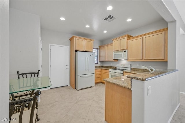 6001 Falconer Ave, Las Vegas, NV 89122 - kitchen featuring white appliances, light brown cabinets, stone countertops, a peninsula, and recessed lighting