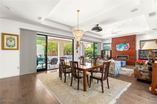 15 Gemstar Ln, Las Vegas, NV 89135 - dining room with visible vents, a raised ceiling, ceiling fan with notable chandelier, and wood finished floors