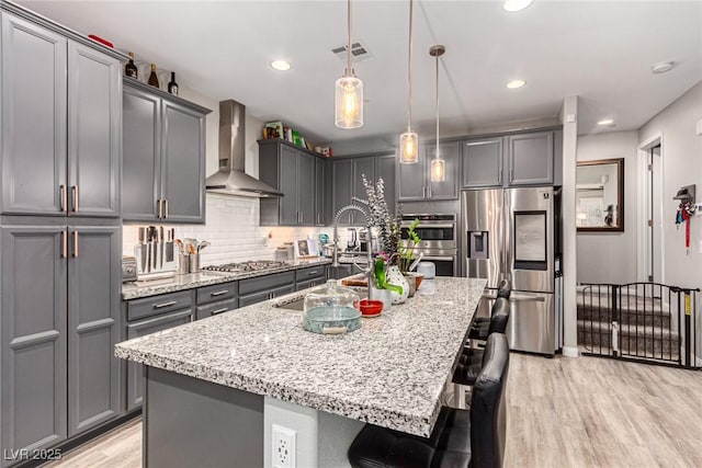 39 Castleton Tower Ct, Henderson, NV 89011 - kitchen with stainless steel appliances, gray cabinetry, and wall chimney exhaust hood