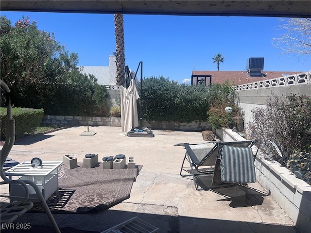 view of patio with central air condition unit and fence