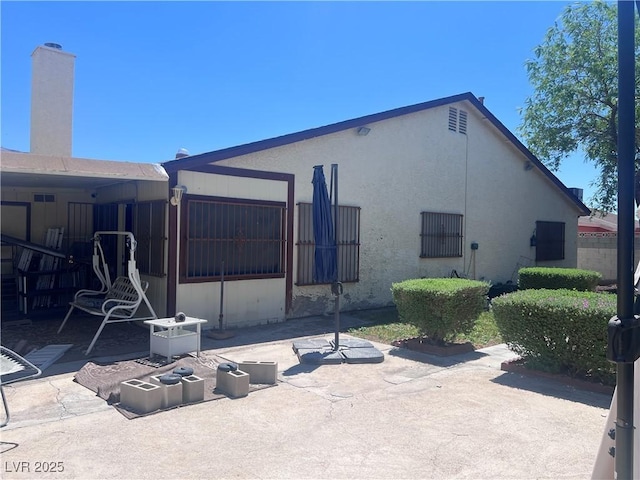 back of property featuring stucco siding and a patio