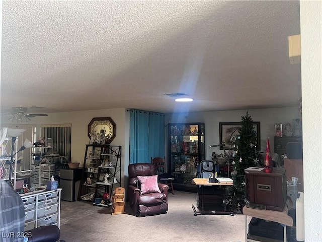 carpeted living area featuring a textured ceiling and ceiling fan